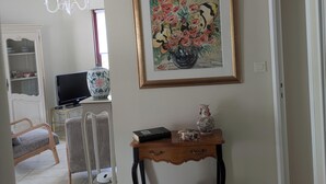 A living room with a television, a vase, and a framed painting on the wall. - Heading to Vannes (Vannes)