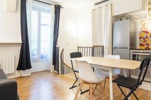 Eine moderne Küche mit Esstisch, Stühlen, Kühlschrank und Herd.
