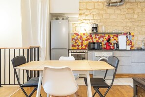 Une cuisine de taille réduite avec un coin repas comprenant une table, des chaises et un four à micro-ondes.