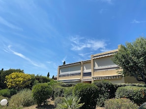 Un bâtiment doté d’un toit plat, de grandes fenêtres et d’une façade beige.