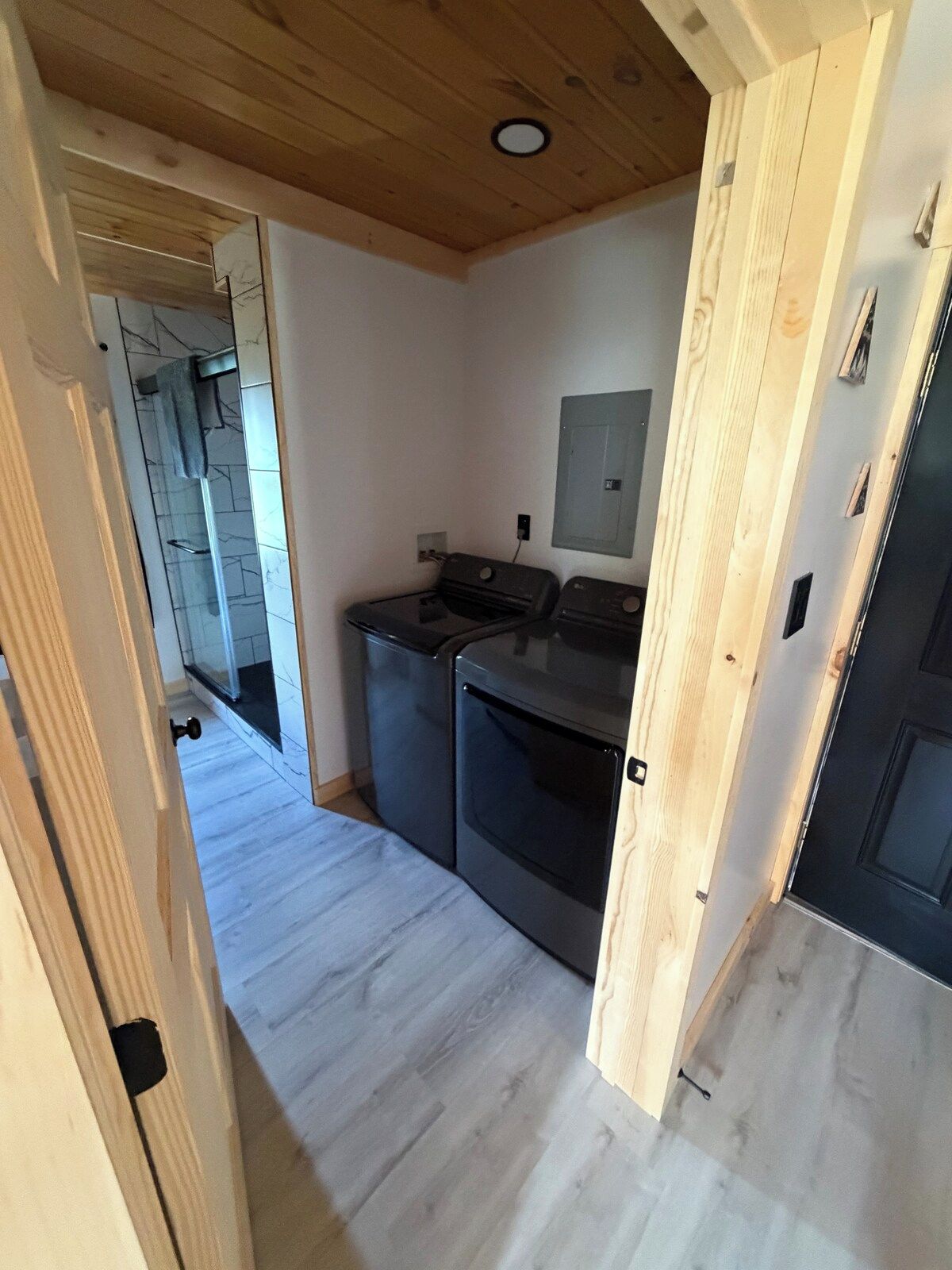A compact kitchen with built-in appliances, a wooden ceiling, and a tiled backsplash.