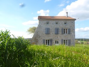 A stone building with a tiled roof, multiple windows with shutters, and a chimney. - Gîte des Gorges de l'Allier: Mountain View, Private Terrace, and Wi-Fi (Alleyras)