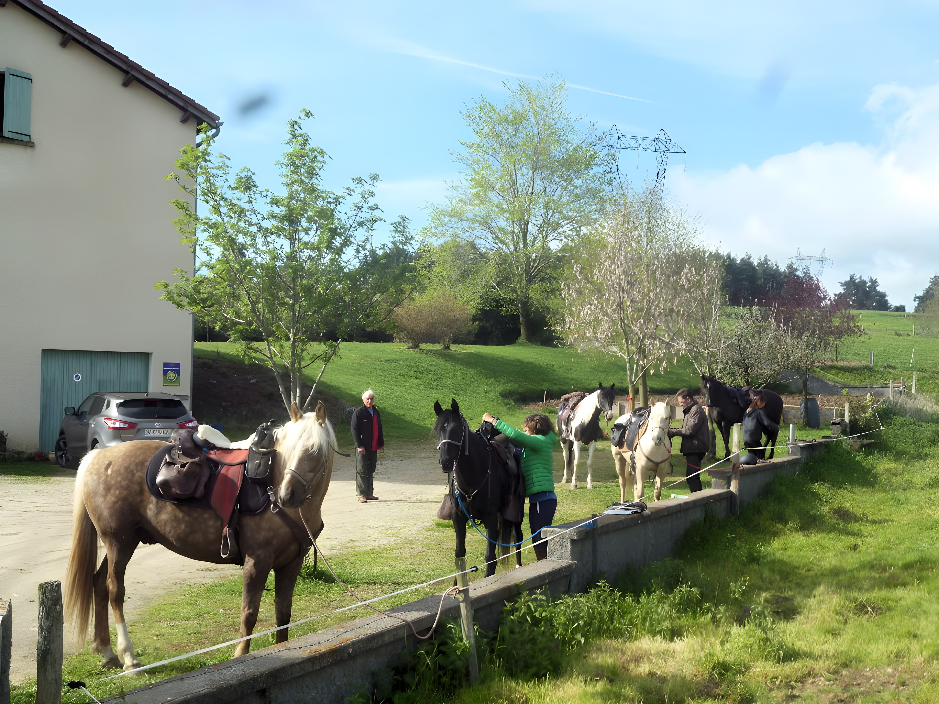A stable with horses and a person leading a horse.
