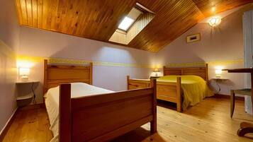 Ein Zimmer mit zwei Holzbetten, einem Oberlicht und Nachttischlampen.