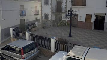 A courtyard with a white building featuring balconies and a gate.