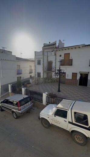 A courtyard with a white building featuring balconies and a gate. - Country House 'Casa La Calza' with Mountain View and Balcony (El Burgo)