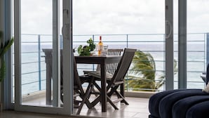 Uma varanda com mesa e cadeiras, uma garrafa de vinho Sutter Home e um copo.