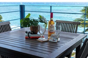 Una mesa de madera con una botella de vino, una copa, un libro, una cámara y una planta.
