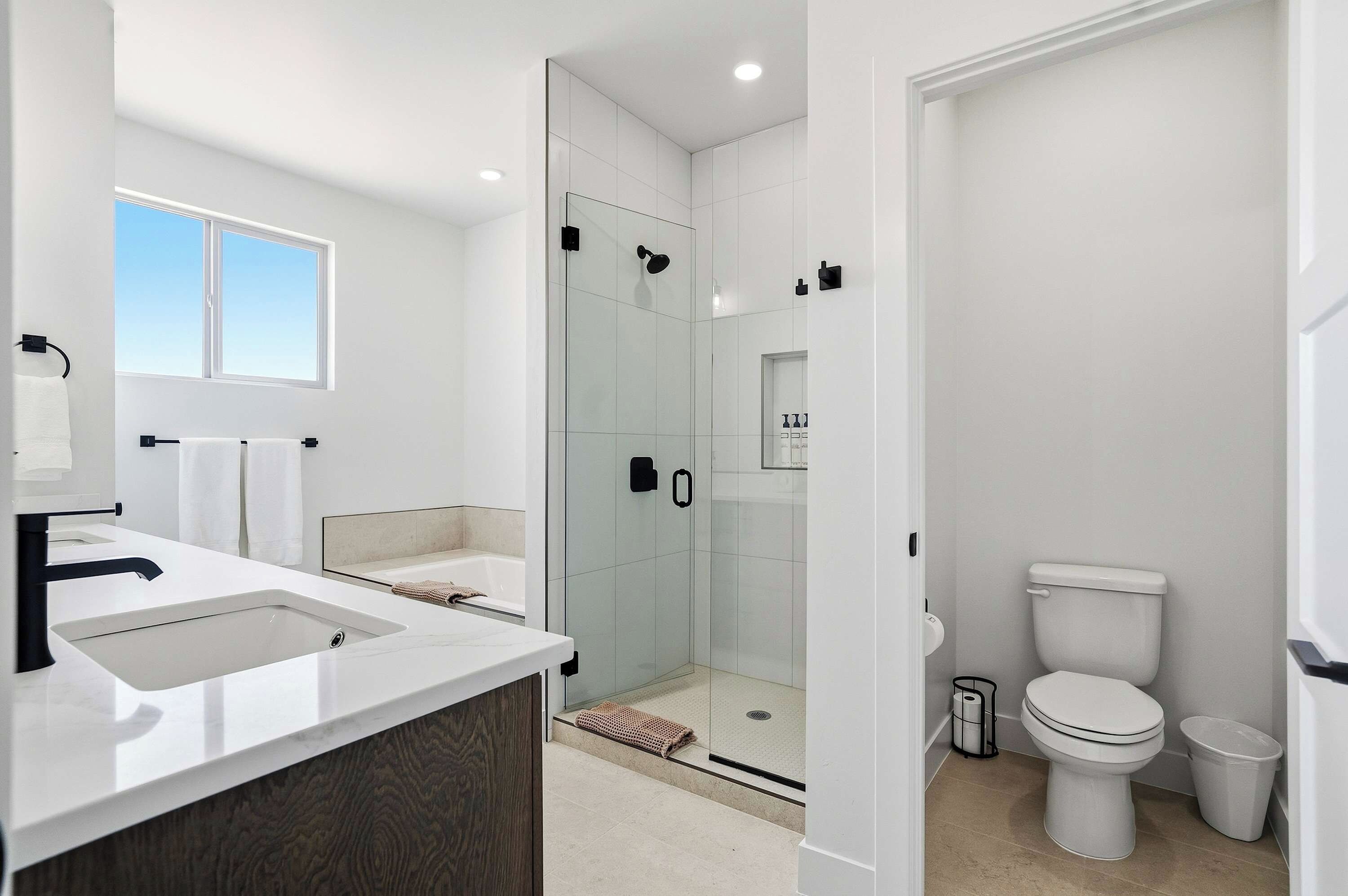 Een moderne badkamer met een douchecabine van glas, een toilet en een wastafel met spiegel.