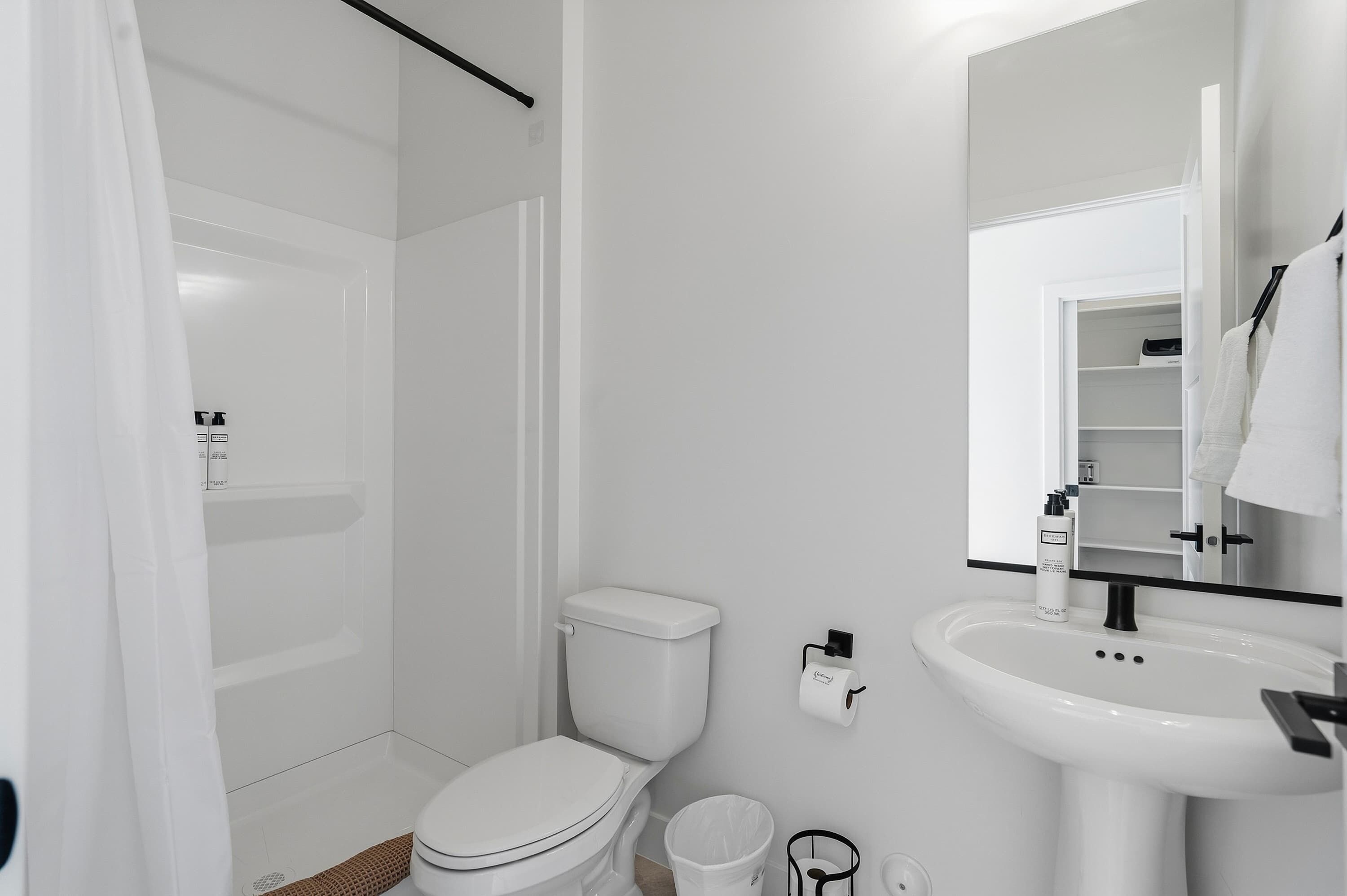 A modern bathroom with a toilet, sink, and shower.