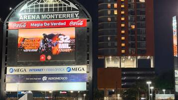 A stadium with a large digital advertisement for Coca-Cola and a sign for Arena Monterrey.