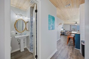 Un intérieur moderne comprenant une salle de bain, un coin repas et une cuisine.