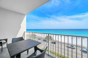 Ein Balkon mit Blick auf Strand und Meer.
