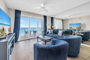 A modern living room with a sofa set, a coffee table, and a TV. There is a balcony with a view of the ocean. - Majestic Sun 503a (Miramar Beach)