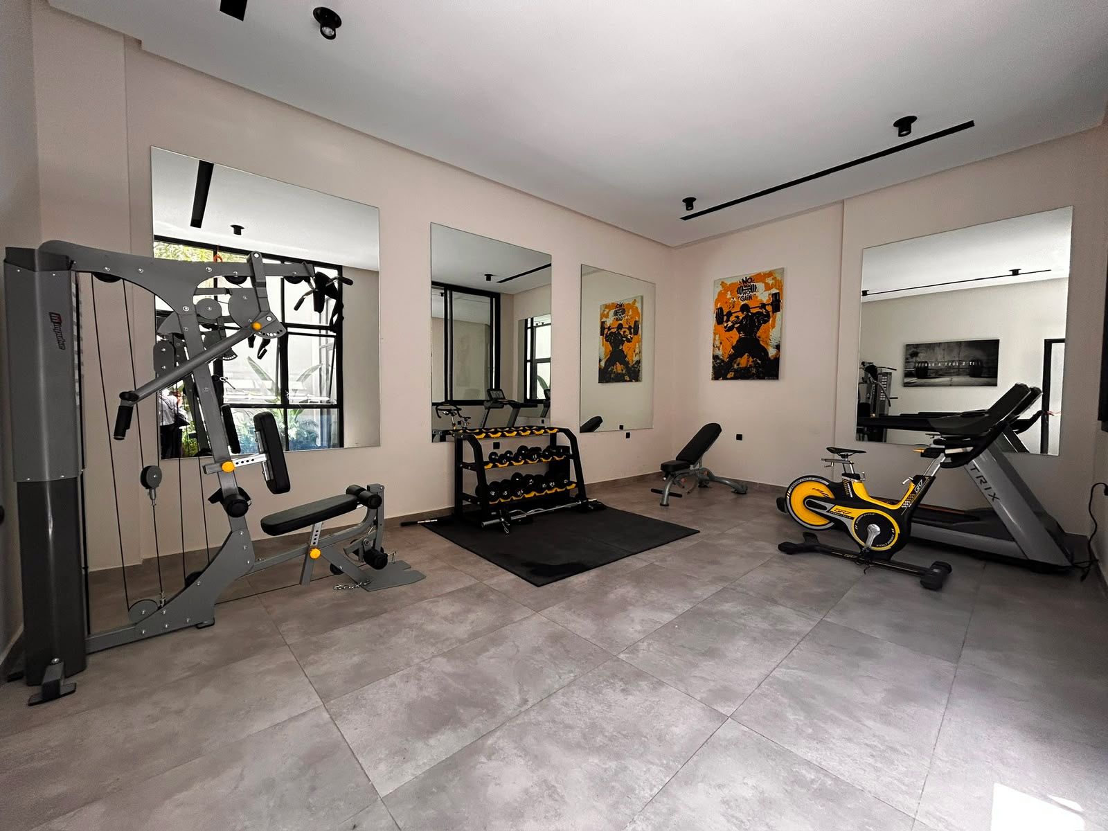 Une salle de sport équipée de matériel d’exercice, de miroirs et d’affiches motivantes.