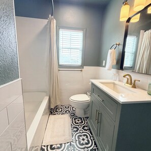 Une salle de bain avec une baignoire, des toilettes et un meuble-lavabo.