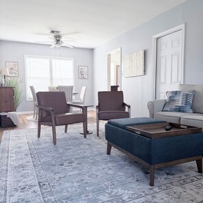 A living room with a sofa, two armchairs, a coffee table, and a rug. - Beautiful, 2-bedroom house with AC, fast WiFi, quiet street, close to downtown. (Corpus Christi)