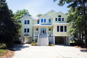 A two-story house with a front porch, a garage, and a driveway. - Soundfront w/ Hot Tub, Game Room & Resort Perks! (Corolla)