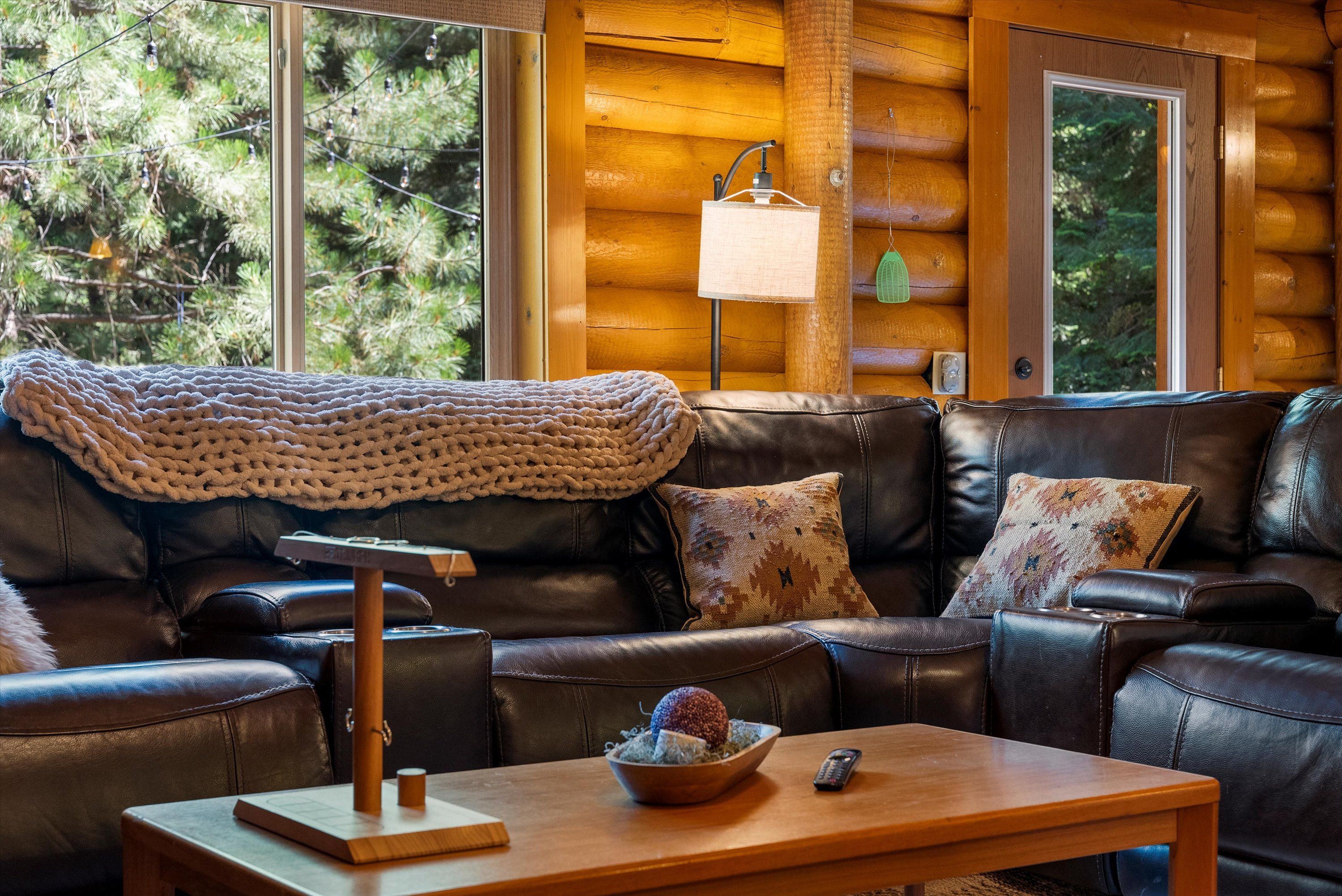 A cozy living room with a leather sofa, a wooden coffee table, and a knitted blanket.