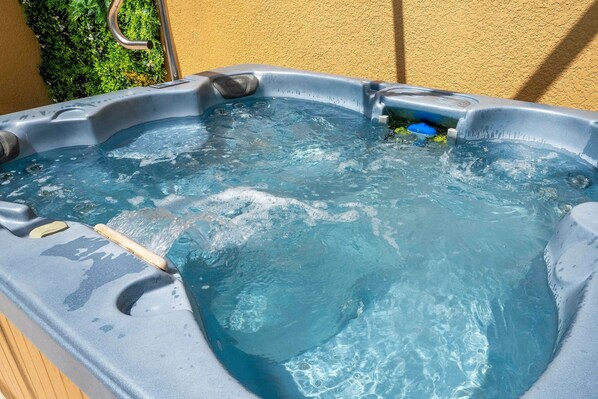 A hot tub with a wooden edge and a metal faucet. - 3BR Themed Rooms Near Disney Private hot tub (Kissimmee)