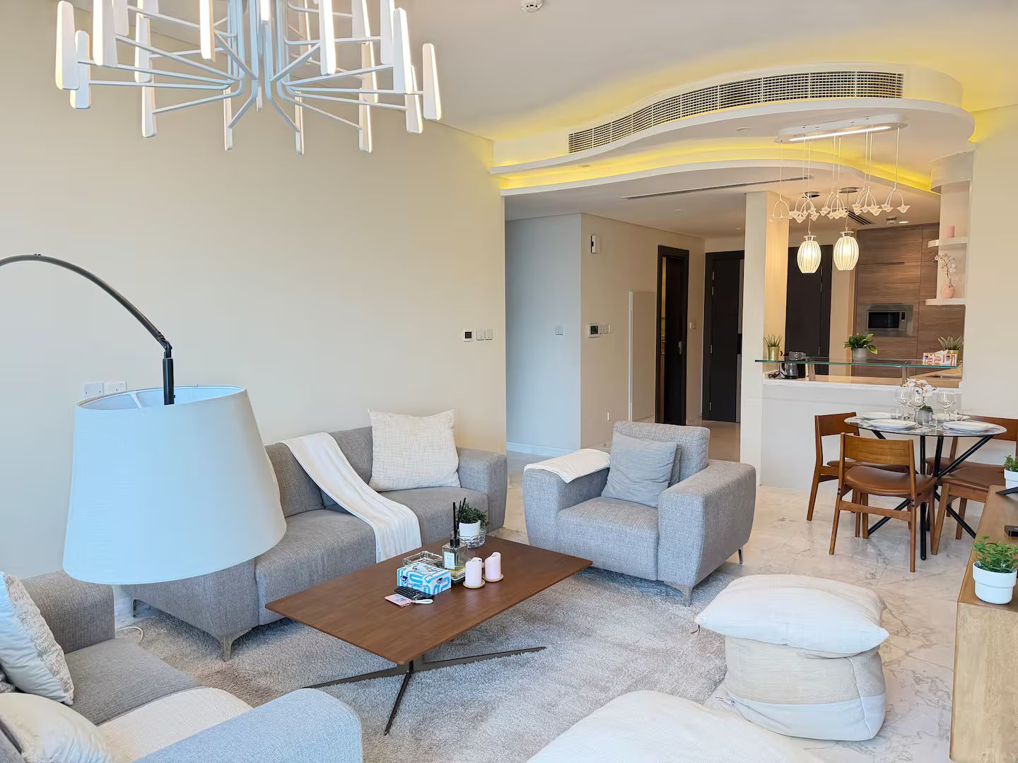 A modern living room with a sofa set, a coffee table, and a dining area with a table and chairs.