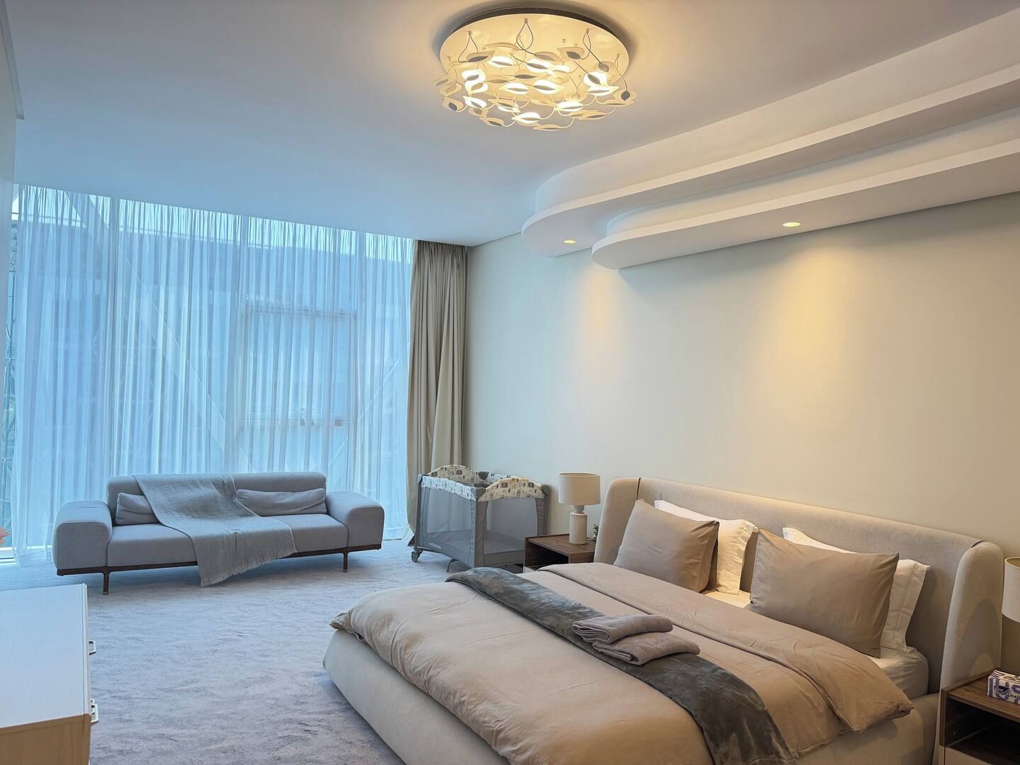 Une chambre à coucher moderne avec un grand lit, un canapé et un bureau.