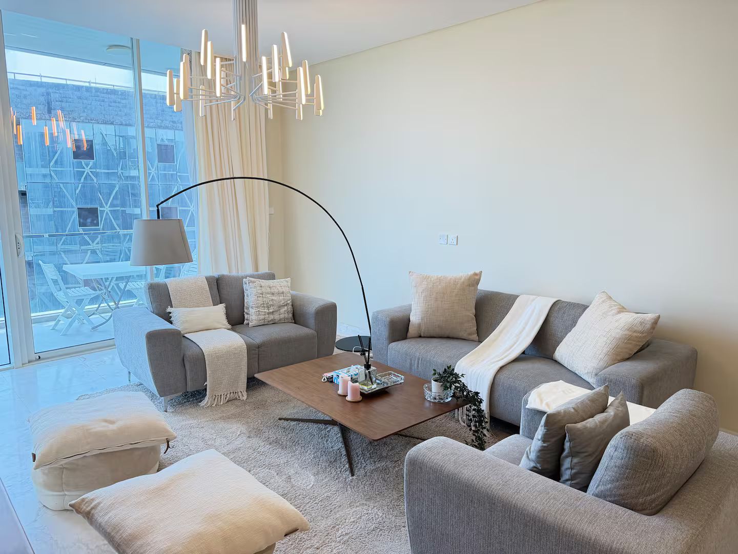 Een moderne woonkamer met een zithoek, een salontafel en een vloerlamp.