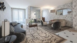 A modern living room with a sofa, armchair, coffee table, and a patterned rug. - LUXURY SIGNORIA APARTMENT WITH ELEGANT INTERIORS & ELEVATOR (Firenze)