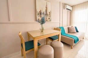 A modern living room with a sofa, a glass-top dining table, and a decorative vase. - Group Vacation • Ocean View • Swimming Pool (Cartagena)