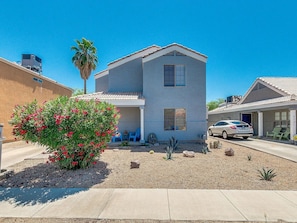 A modern two-story house with a covered patio, a car parked in front, and a small garden with a flowering plant. - Min 2 Mayo Clinic, St. Joseph's Hospital, Chase Stadium, Desert Botanical Garden (Phoenix)