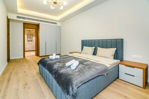 Un dormitorio con cama, mesita de noche, armario y lámpara de techo.