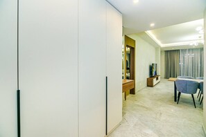 Una sala de estar moderna con comedor, televisor y un ventanal con cortinas.