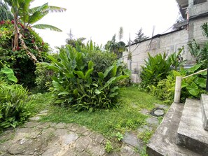 A garden with various plants and a stone pathway. - Casa Bentley: 360° rooftop terrace + lush garden (San Pedro La Laguna)