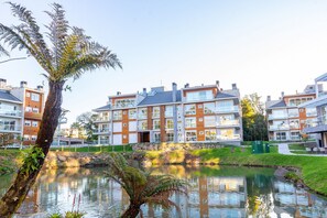 A residential building with multiple floors, large windows, and a stone facade. - Vêneto Vicenza 103 (Gramado)