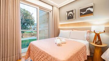 A hotel room with a bed, a nightstand, a lamp, and two framed pictures on the wall.