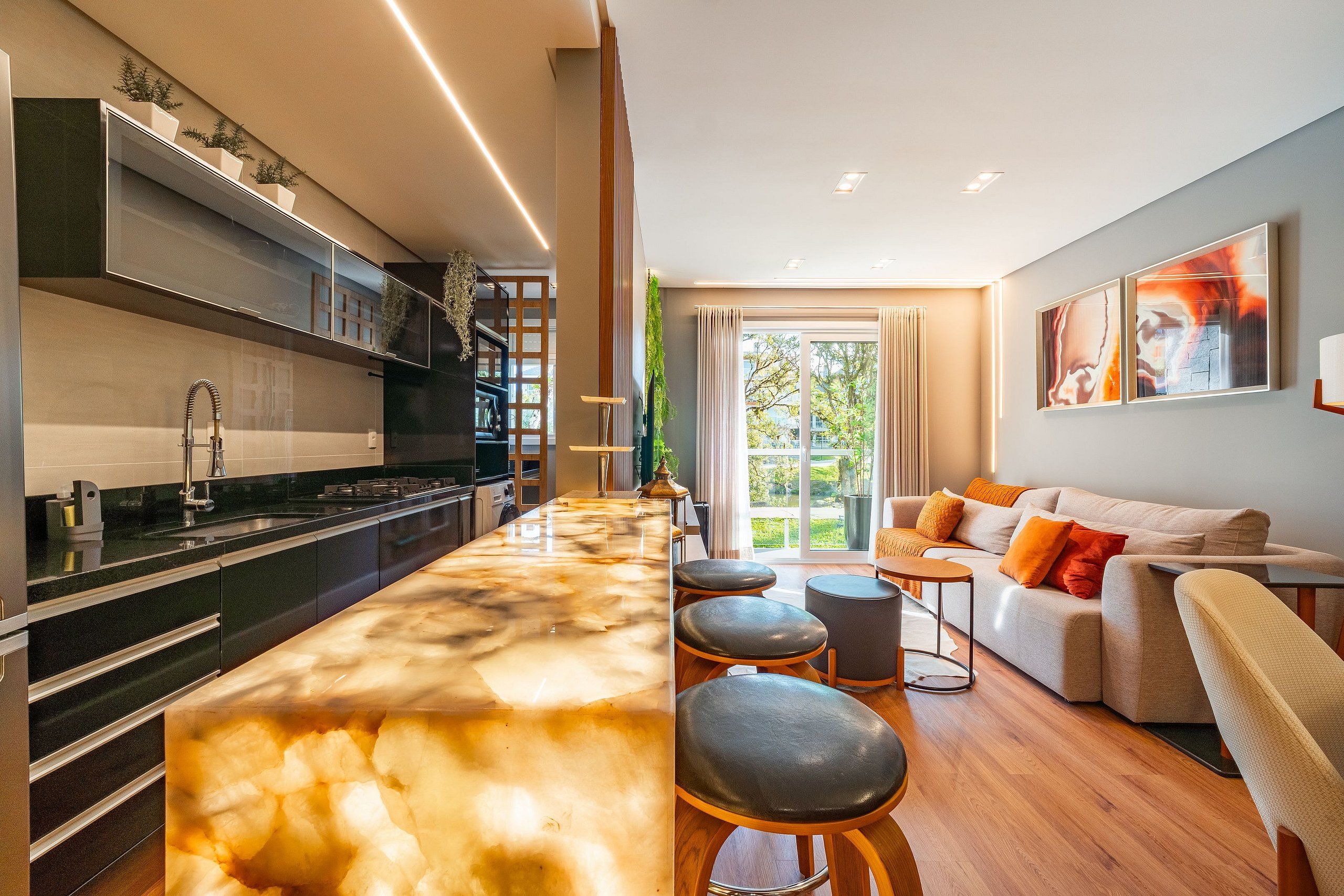 A modern kitchen with a marble countertop and a dining area with a sofa and stools.