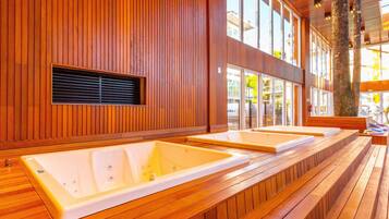 A spa area with wooden paneling and two large tubs.