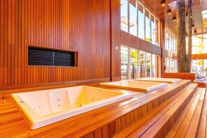 A spa area with wooden paneling and two large tubs. - Vêneto Vicenza 103 (Gramado)