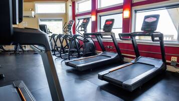 Un gimnasio con cintas de correr y equipo de ejercicio.