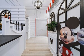 A modern interior with a Mickey Mouse decoration, a staircase, and a hallway leading to a door. - 7BR house with private pool in clermont (Clermont)