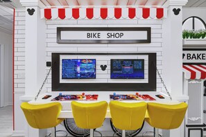 A room with a white wall, a sign reading 'BIKE SHOP', two monitors, and three yellow chairs. - 7BR house with private pool in clermont (Clermont)