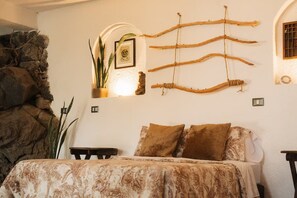 Un dormitorio con una cama, una planta montada en la pared y decoración rústica.