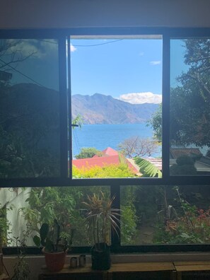 Una ventana con vista a un paisaje montañoso y un cuerpo de agua.