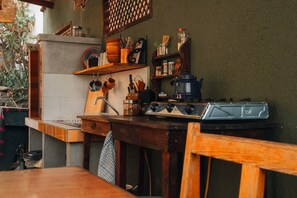 Una cocina con encimera de madera, estufa y diversos utensilios de cocina.