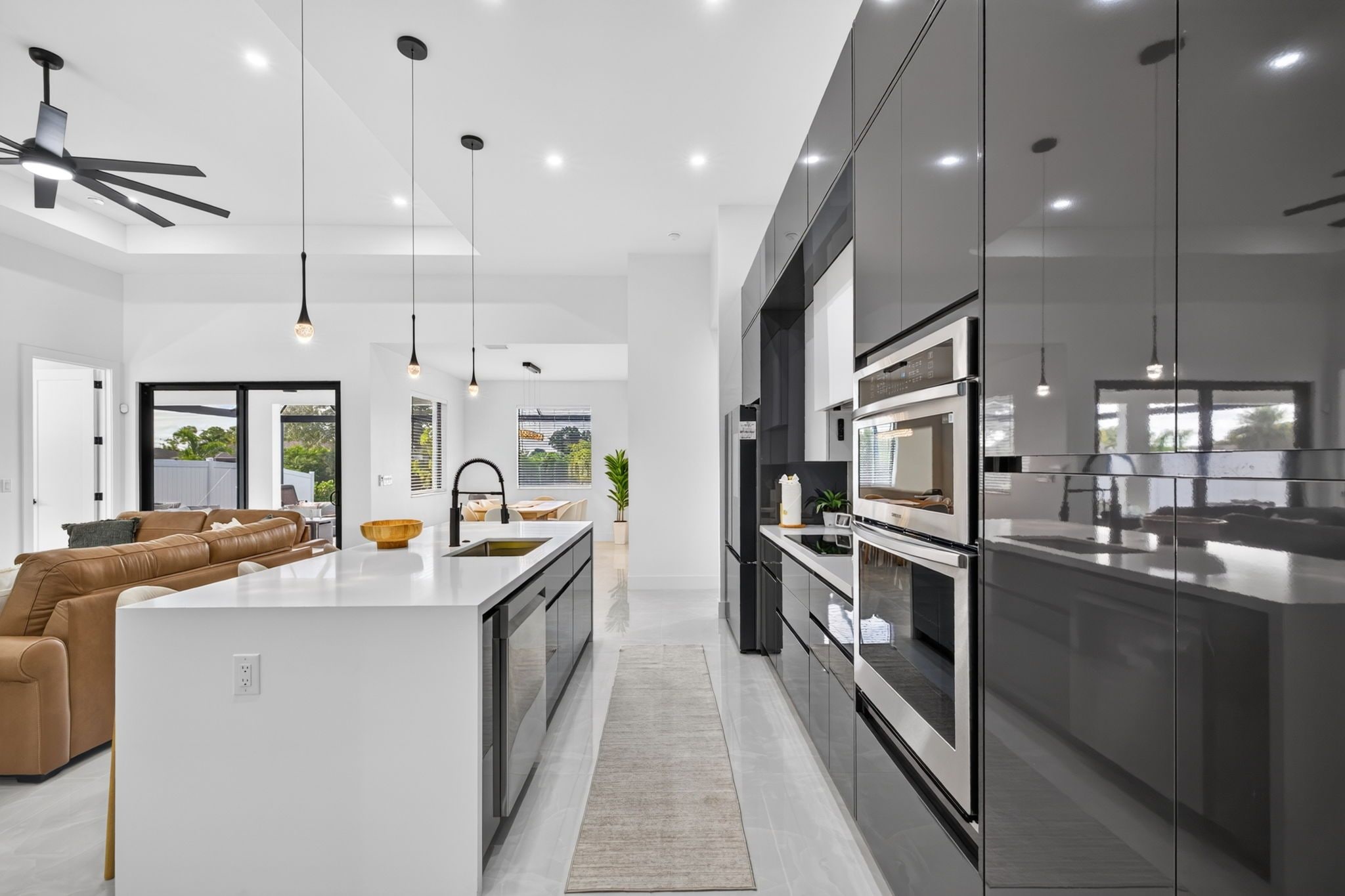 A modern kitchen with a central island, stainless steel appliances, and pendant lighting.