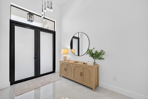 Ein modernes Interieur mit einer Schiebetür, einem Holzschrank mit Spiegel und einer Pflanze.