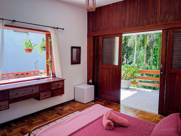 A room with a wooden bench, a small white appliance, a pink towel, and a view of greenery outside. - Casa Smile (Teresópolis)