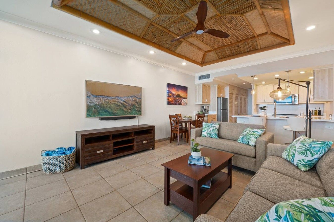 A living room with a sofa, coffee table, TV, and artwork on the wall.