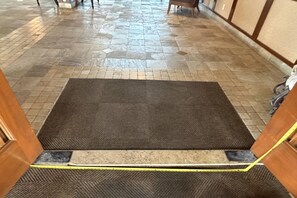 A hotel entrance with a tiled floor, a brown carpeted area, and a yellow measuring tape on the floor. - Lahaina Shores Beach Resort, Ocean Views Sleeps 5 (Lahaina)