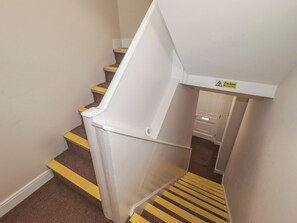 Eine Treppe mit gelben Sicherheitsstreifen und einem Warnschild.